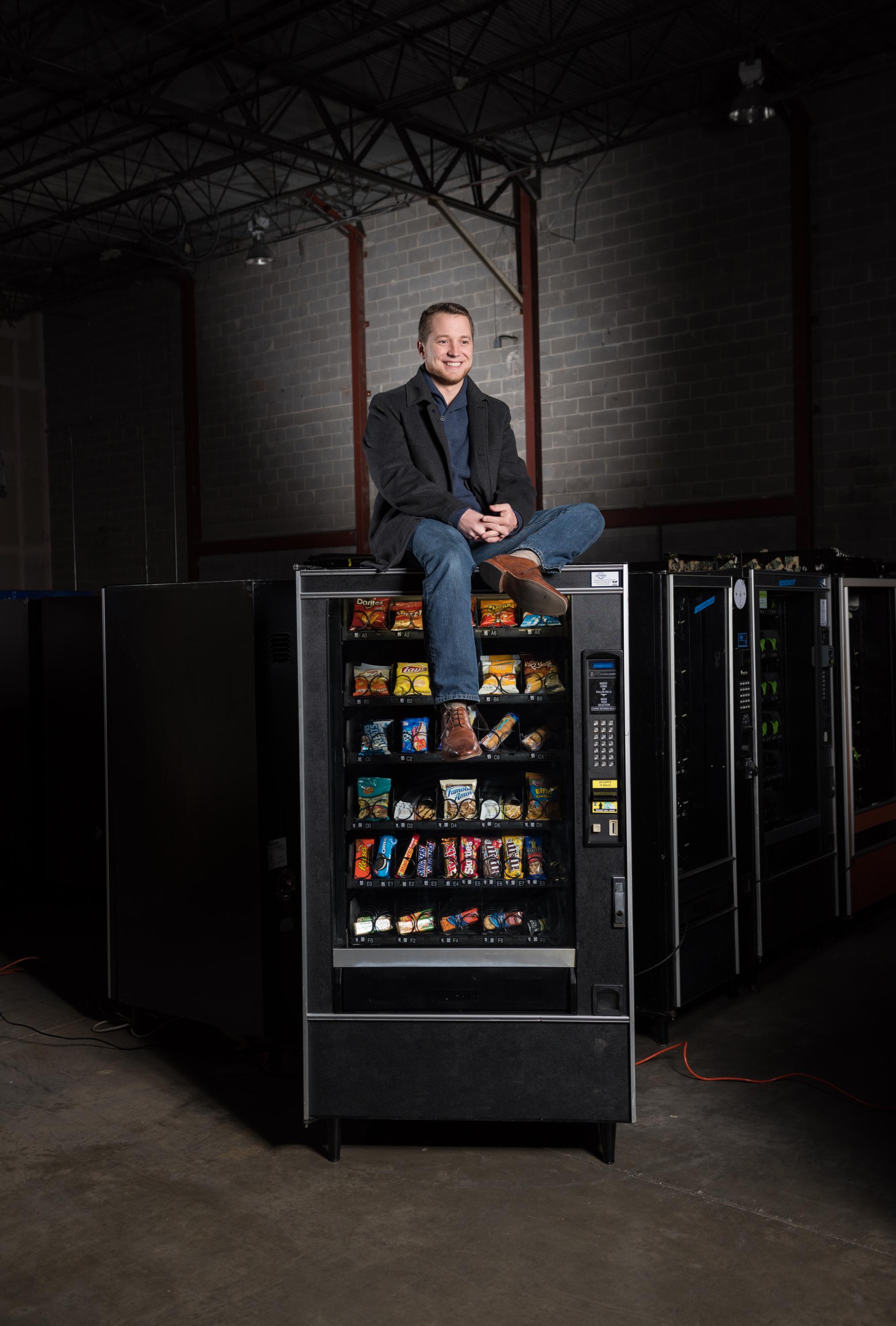 Cory Hewett, co-founder and CEO of Gimme Vending, with vending machines. Gimme Vending completed the 2014 Startup Summer program. 